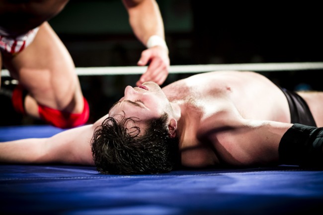 Pro wrestler, lying on the floor being counted out